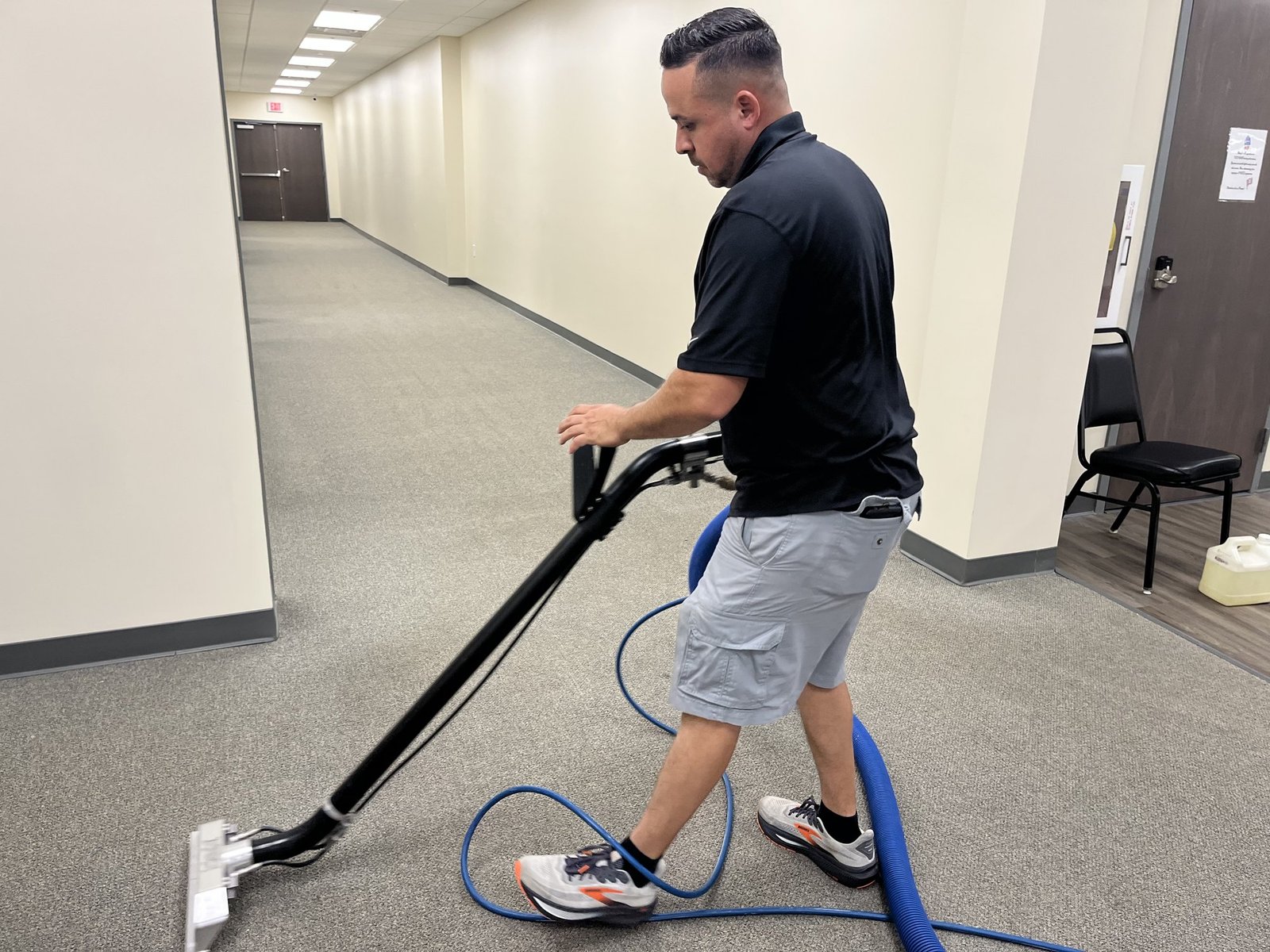 Technician professionally cleaning carpet in an Emerald Coast property