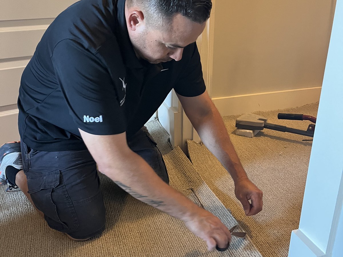 Technician performing a detailed residential carpet repair