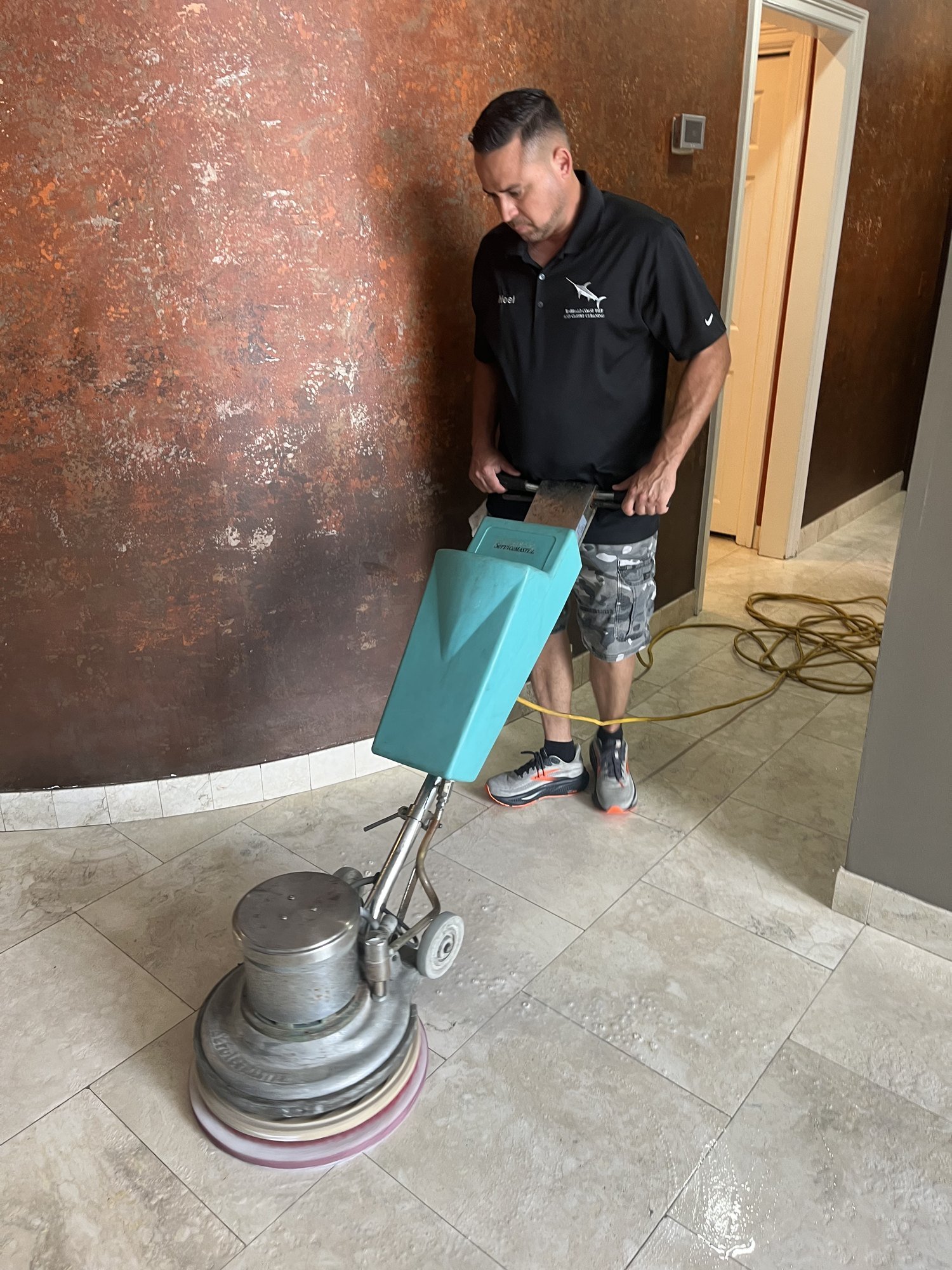 Technician polishing a natural stone floor in a coastal property
