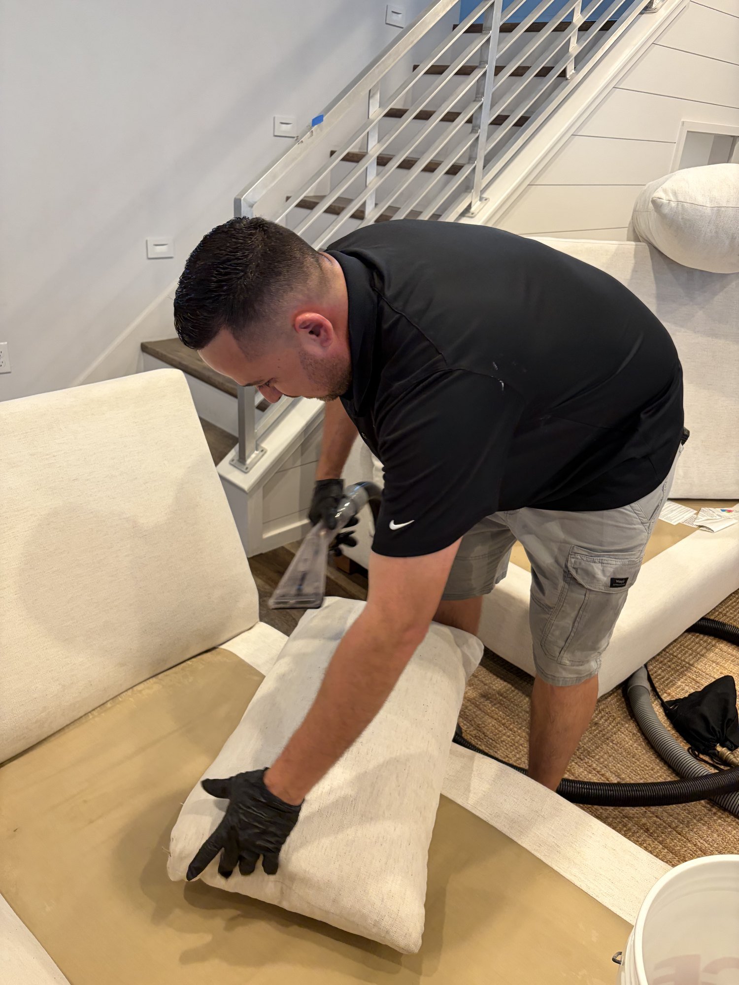 Technician carefully cleaning light upholstered cushions