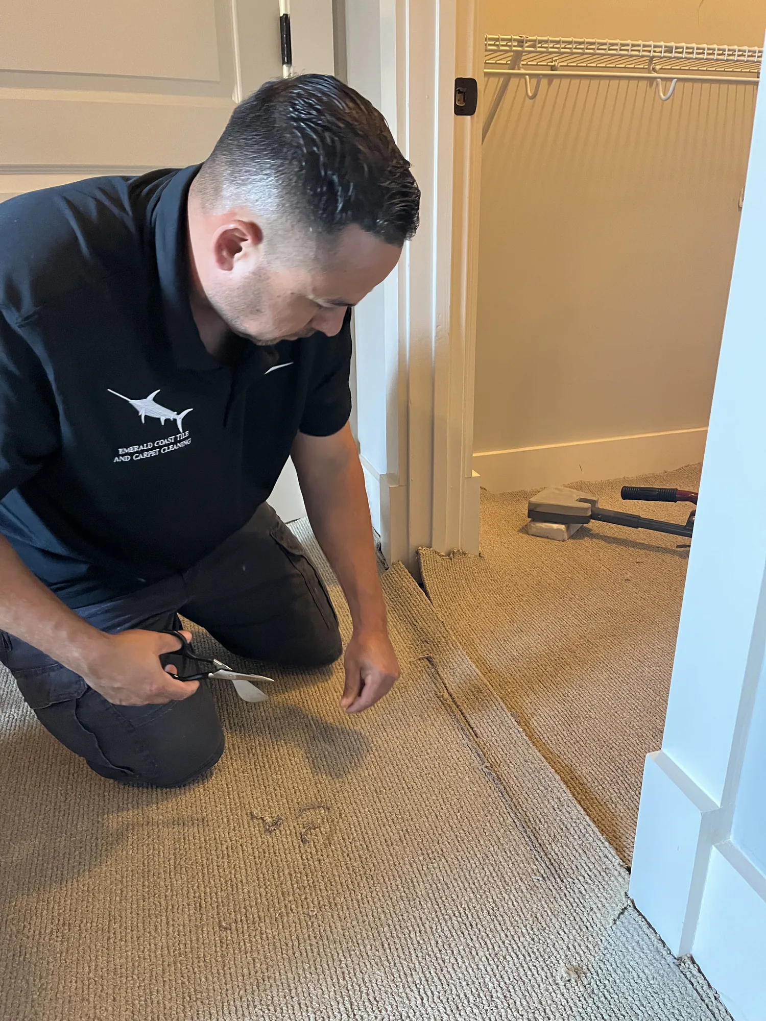 Close view of a technician working on a carpet edge.