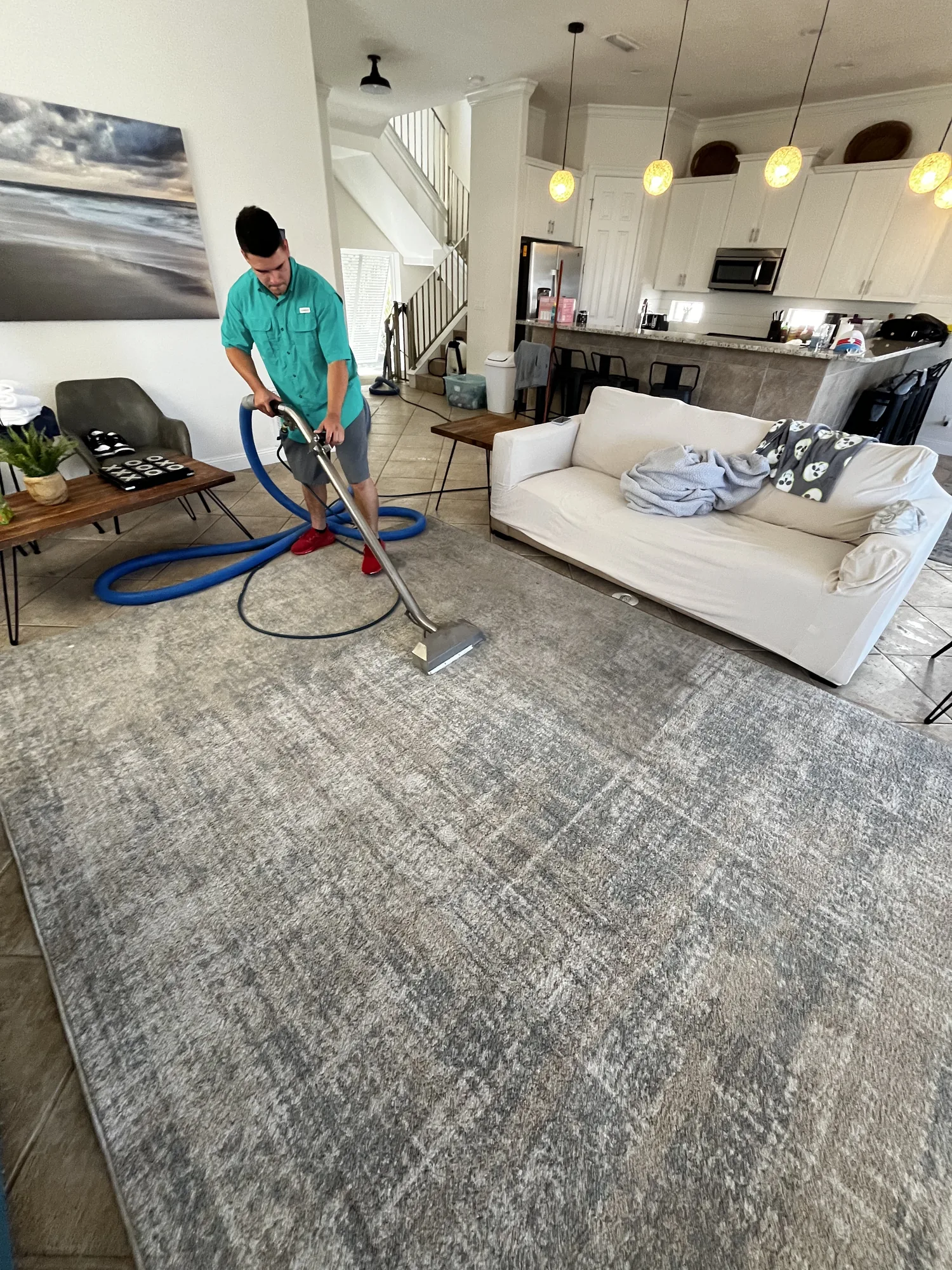 Technician working on an area rug in a furnished living room.
