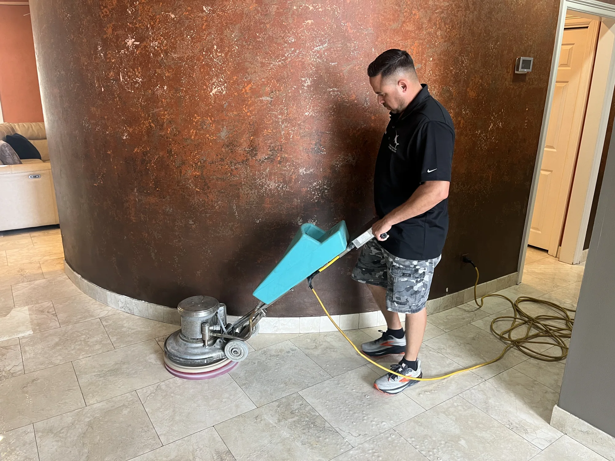 Technician polishing a natural-stone floor in a home.