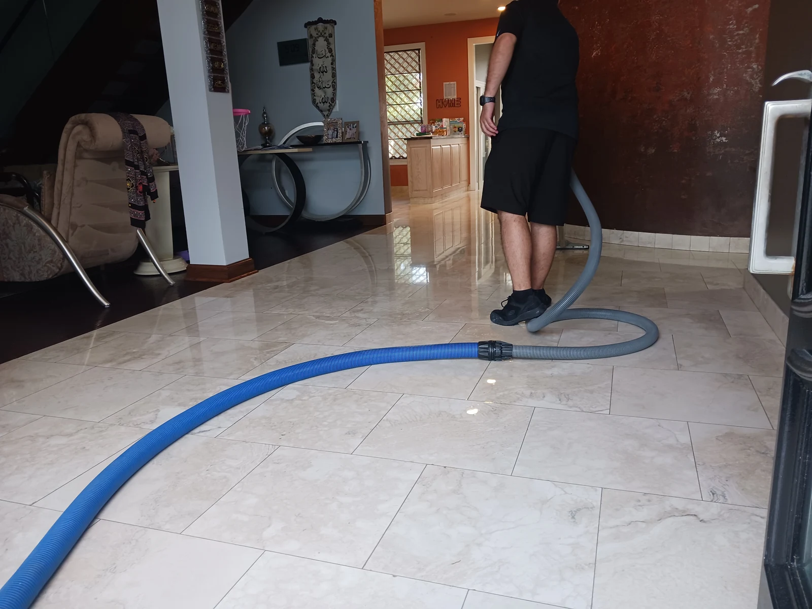 Finished dry sections of a natural-stone floor with cleanup equipment still in the room.